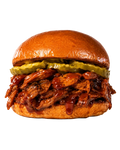 BBQ Brisket sandwich on a bun topped with pickles and BBQ sauce 